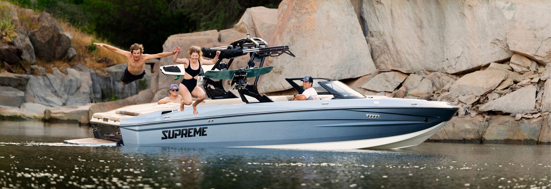 Supreme wake boat with riders on the water